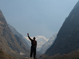 Man Standing in Himalayan Valley with Snowy Peaks