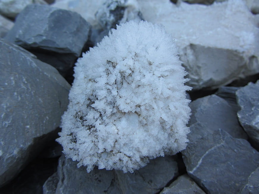 Close-up of white frost crystals on gray rocks