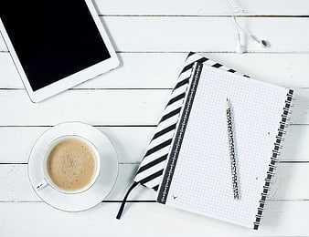 Flat lay workspace with coffee, tablet, and notebook