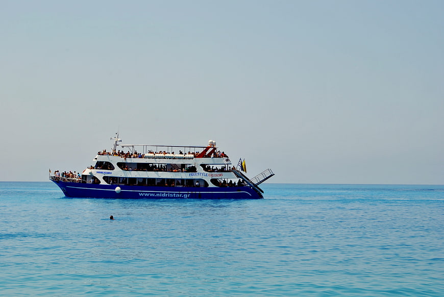 Blue and white cruise ship sailing on calm turquoise sea