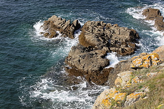 Aerial view of rugged coastal rocks and crashing ocean waves