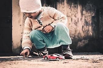 Toddler boy playing with toy car outdoors