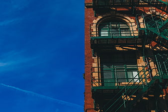 Low Angle View of Brick Building with Green Fire Escape