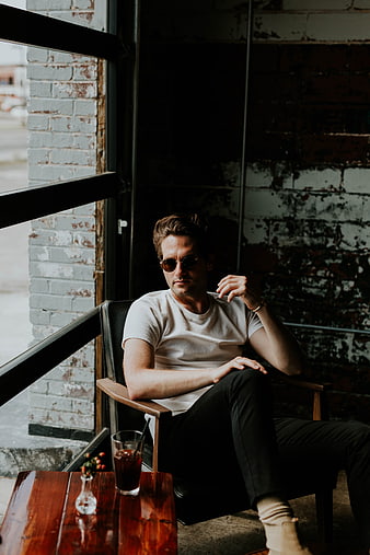 Man in Sunglasses Sitting in Industrial Cafe Interior