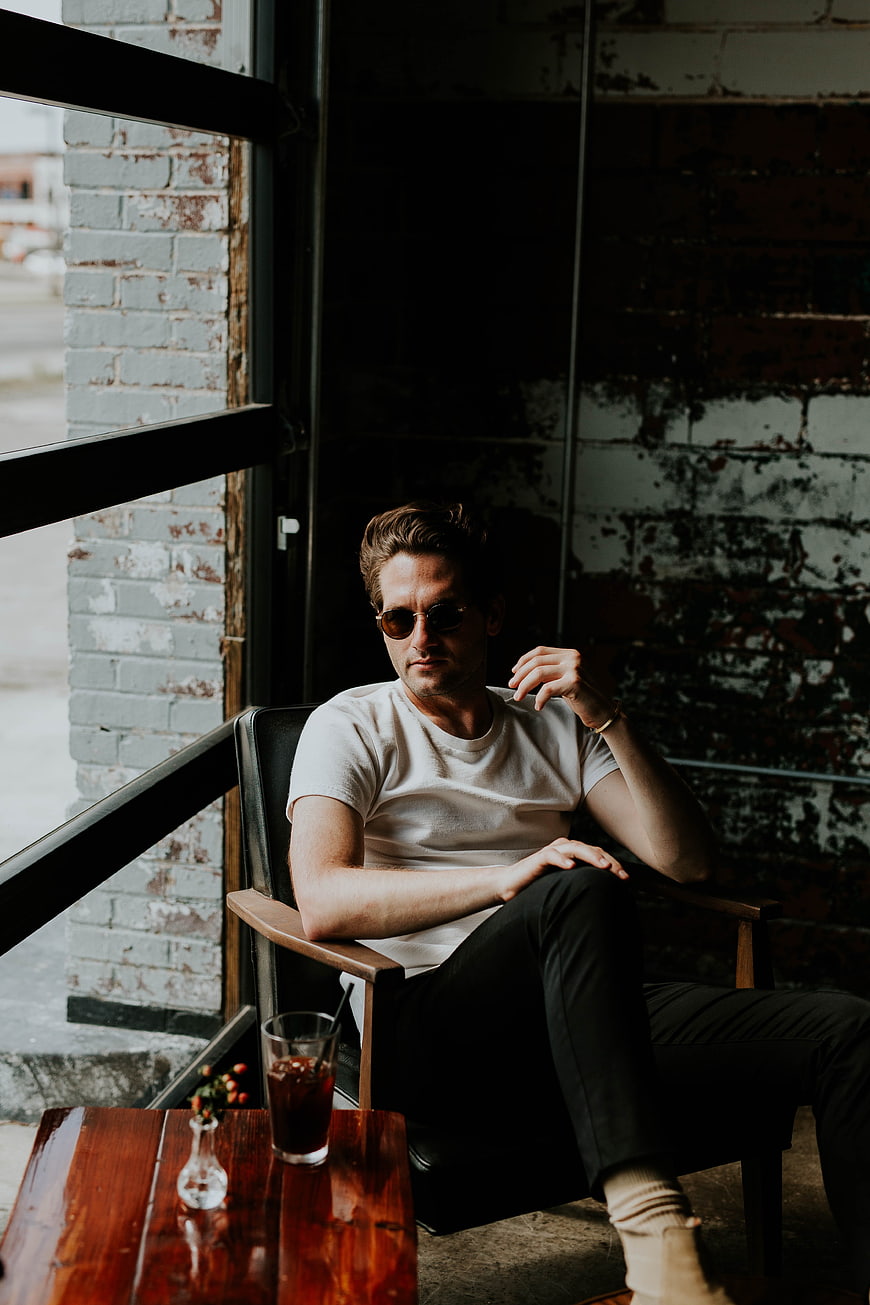 Man in Sunglasses Sitting in Industrial Cafe Interior