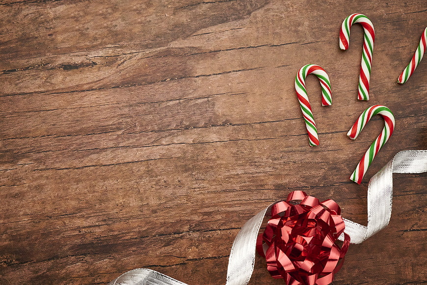 Christmas Candy Canes and Red Bow on Wooden Background