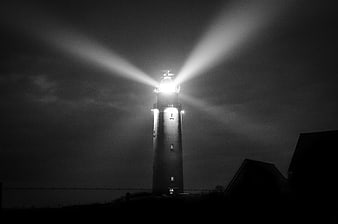 Black and white lighthouse beams at night