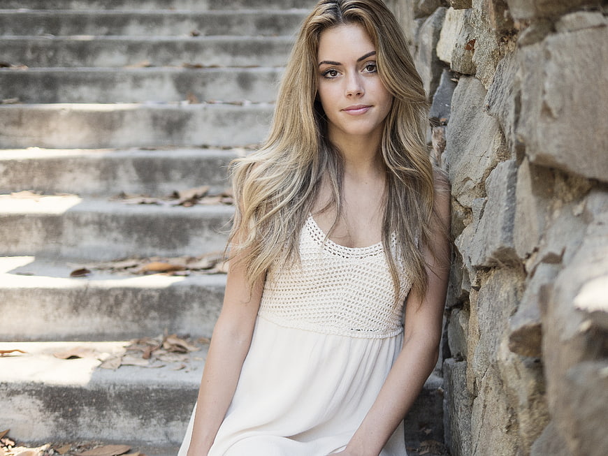 Young Blonde Woman in White Dress Sitting on Stone Steps