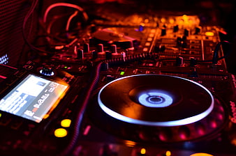 Close-up of DJ turntable and mixer in club lighting
