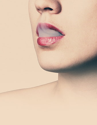 Close-up of woman's lips with red lipstick and smoke