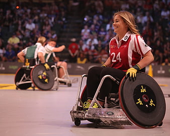 Female wheelchair rugby player smiling during indoor match
