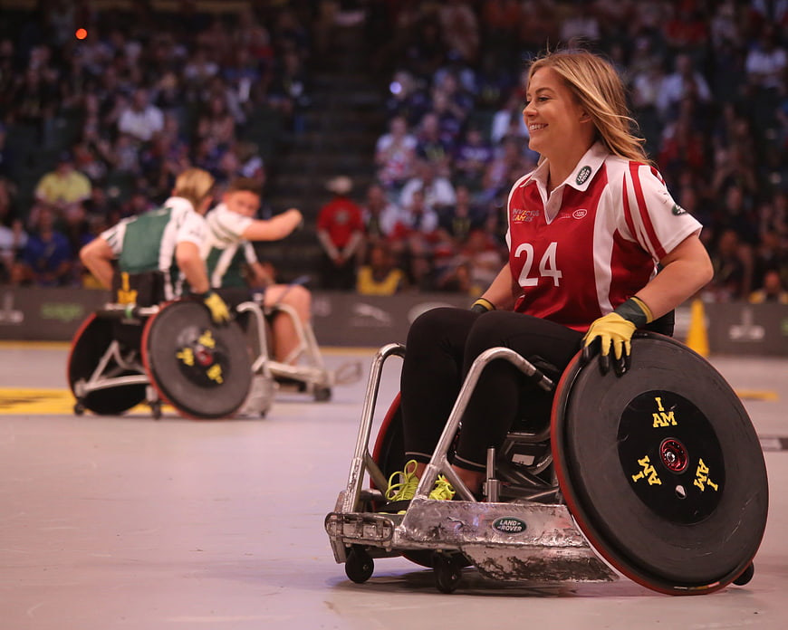 Female wheelchair rugby player smiling during indoor match