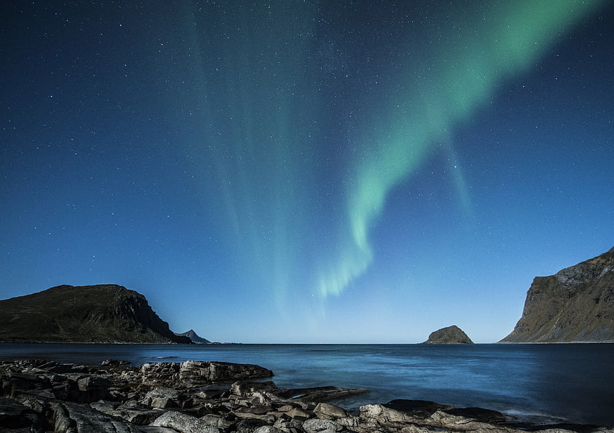 Green Aurora Borealis Over Rocky Coastal Landscape at Night