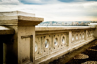 Vintage concrete balustrade overlooking city skyline and ocean