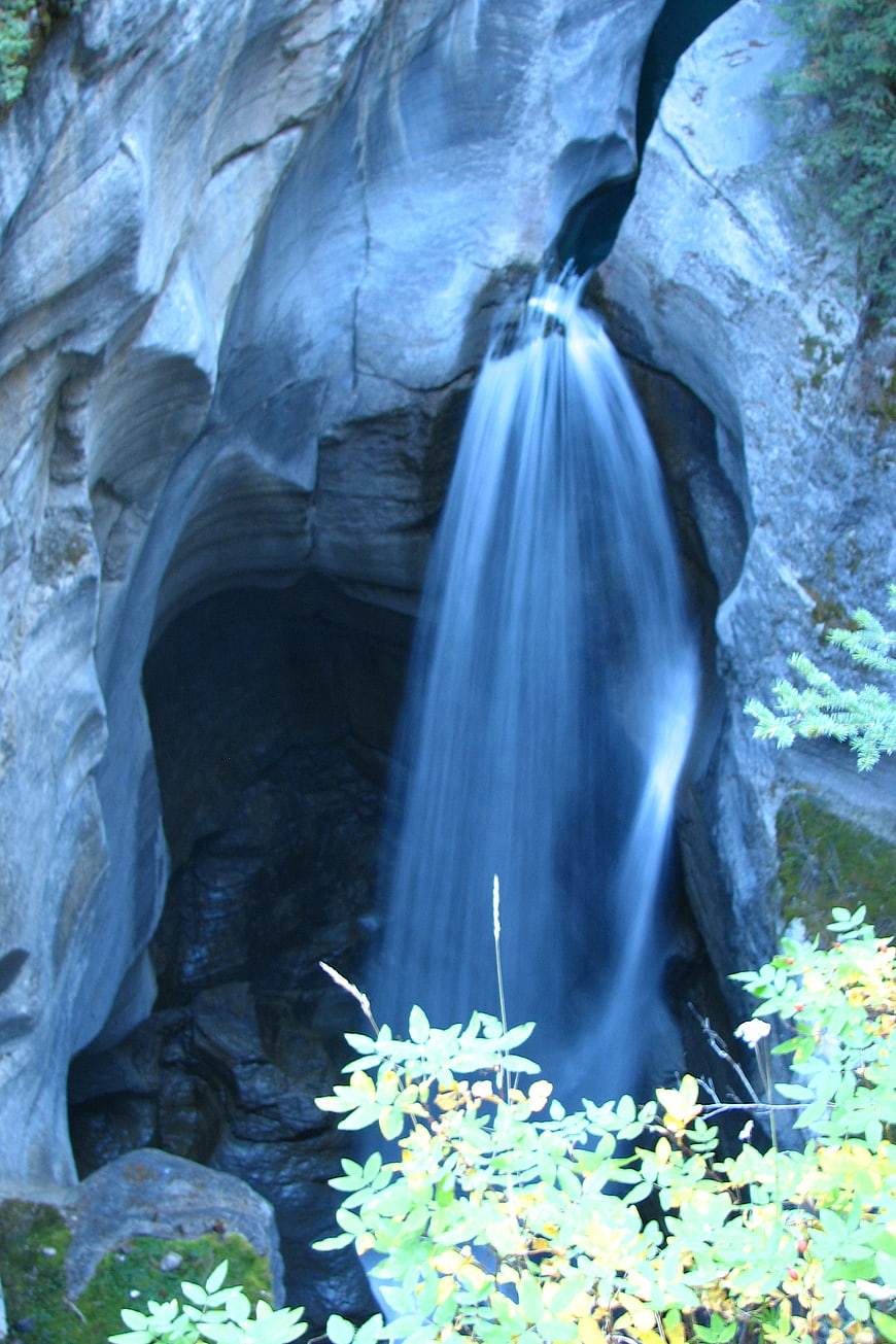 Silky waterfall cascading through rocky cave opening