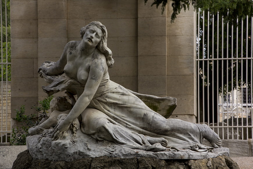 Weathered Marble Statue of Reclining Woman in Park