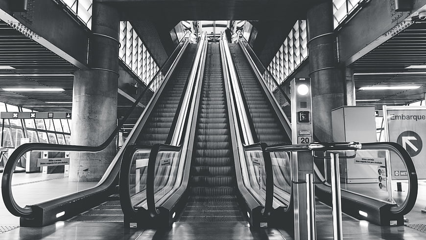 Symmetrical Black and White Escalator in Modern Transit Station