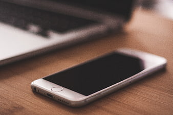 White Smartphone on Wooden Desk with Laptop
