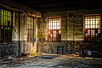Abandoned industrial workshop interior with sunlight streaming through windows