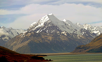 Majestic Snow-Capped Mountain Peak Over Lake and Valley