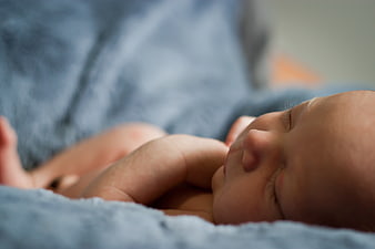Close-up of sleeping newborn baby on blue blanket