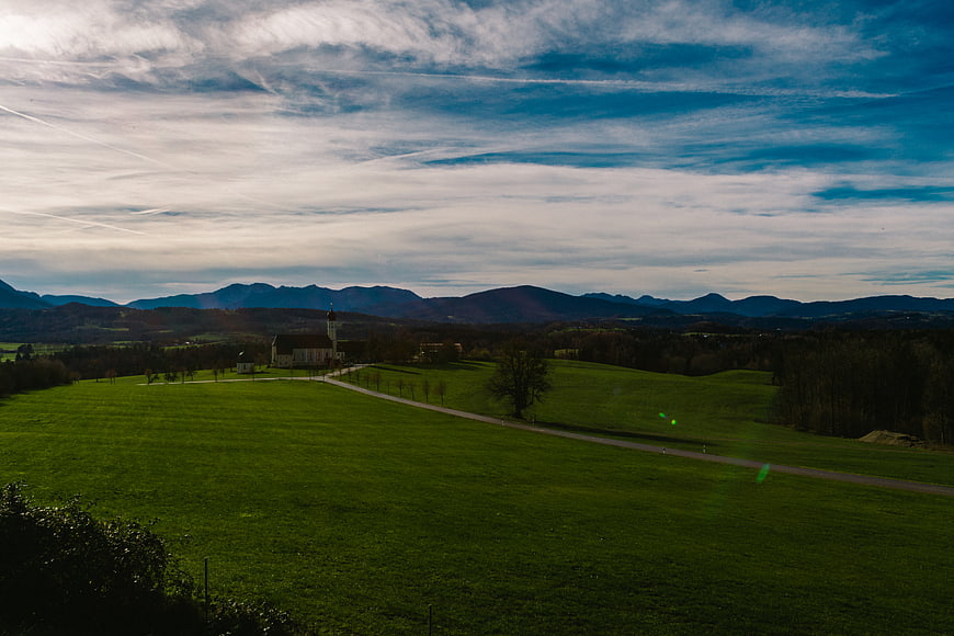 Serene Green Landscape with Church and Mountains