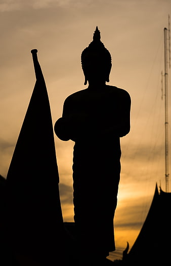 Silhouette of Buddha Statue Against Golden Sunset Sky