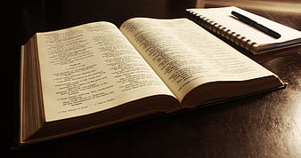 Open Bible with Notebook and Pen on Wooden Table
