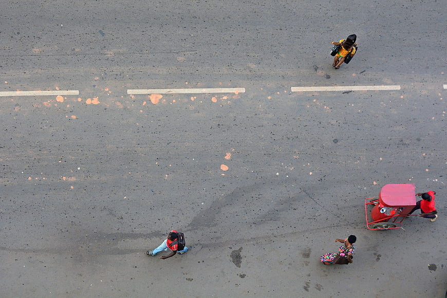 Aerial view of pedestrians and street vendor on gray road