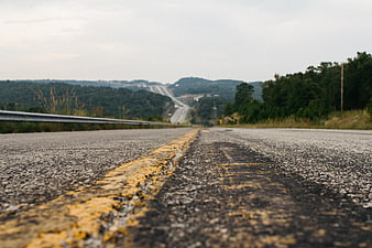 Low angle view of yellow road line on asphalt highway