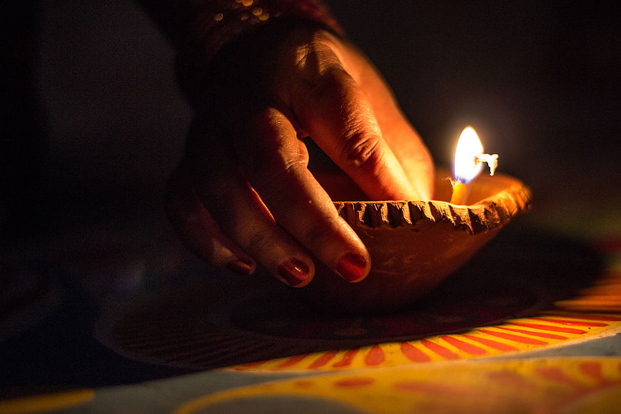 Lighting Traditional Clay Oil Lamp During Diwali Festival