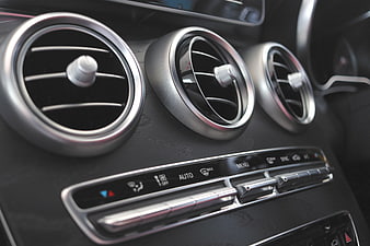 Close-up of luxury car dashboard air vents and climate control panel
