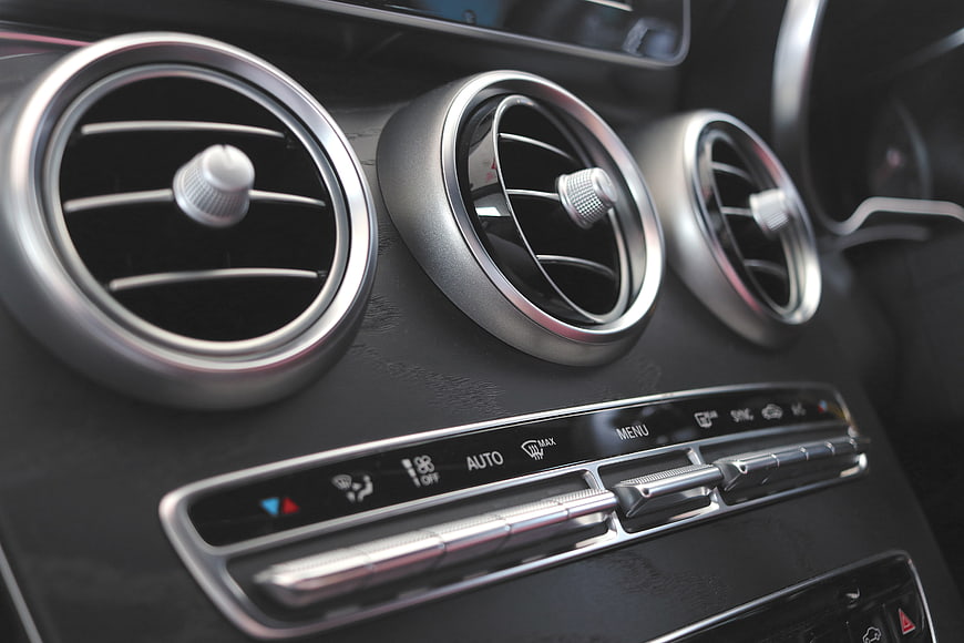 Close-up of luxury car dashboard air vents and climate control panel