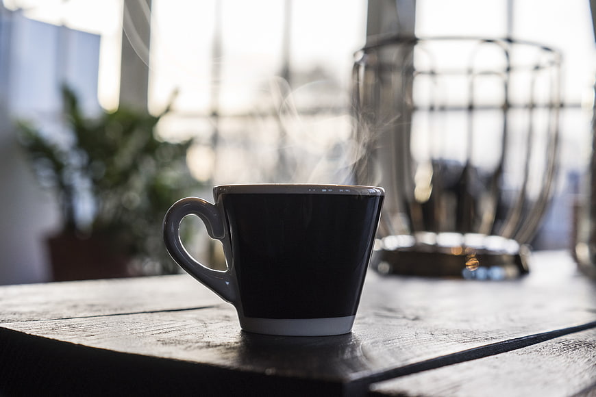 Steaming Black Coffee Cup on Rustic Wooden Table