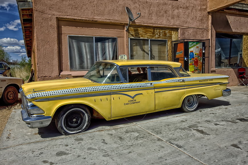 Vintage Yellow Edsel Ranger Taxi Cab Parked Outside Building