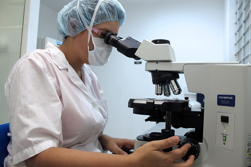 Female scientist using microscope in laboratory
