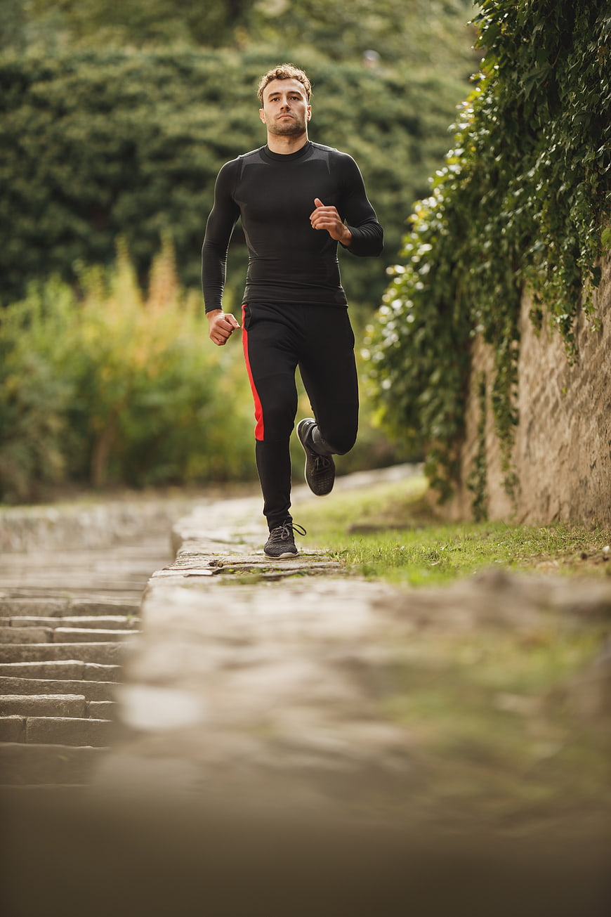 Athletic Man Running on Stone Path in Park
