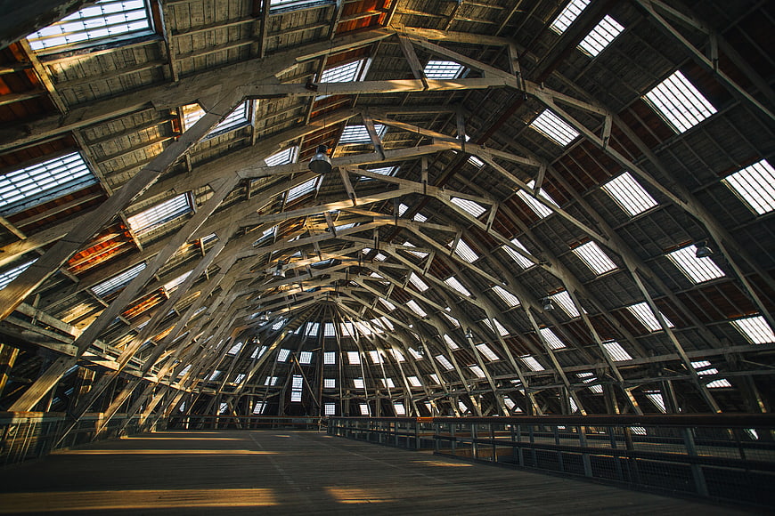 Interior of historic wooden dockyard building with arched roof