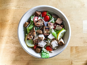 Overhead view of grilled chicken Caesar salad in a bowl