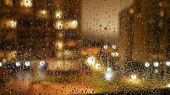 Raindrops on Window with Blurred City Lights Background