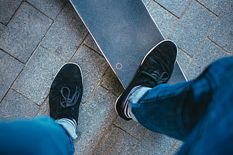 First-person view of feet on skateboard on pavement