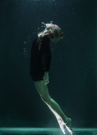 Underwater Portrait of Woman Floating in Dark Water