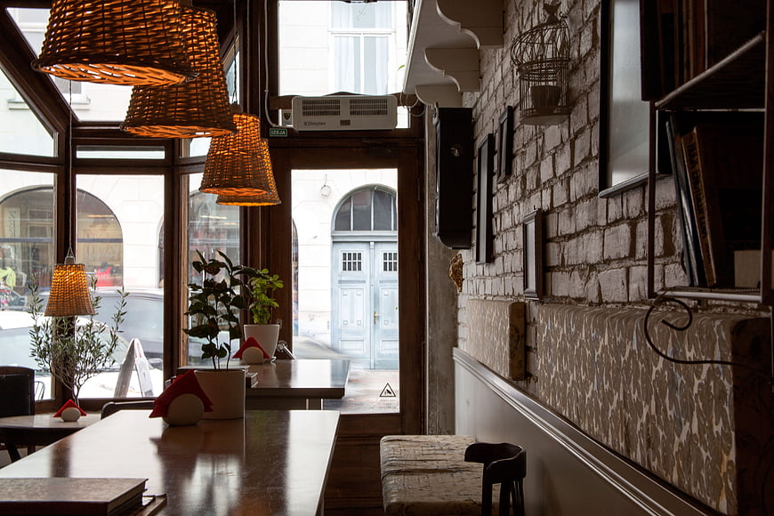 Cozy cafe interior with wicker lamps and brick wall