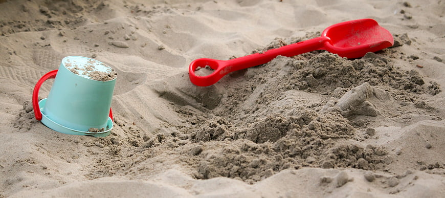 Red Shovel and Teal Bucket in Sand