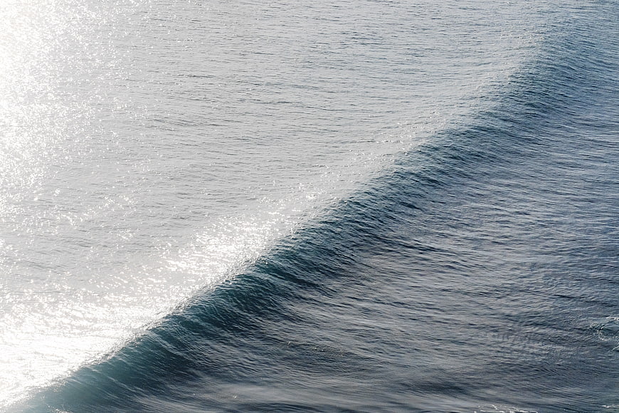 Aerial View of Ocean Wave with Sunlight Reflection