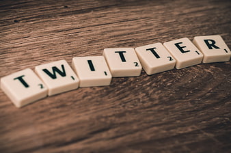 Twitter spelled with Scrabble tiles on wooden background