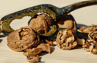 Cracked Walnuts and Vintage Nutcracker on Wooden Surface
