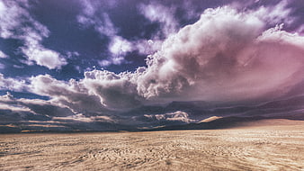 Dramatic purple clouds over vast desert landscape