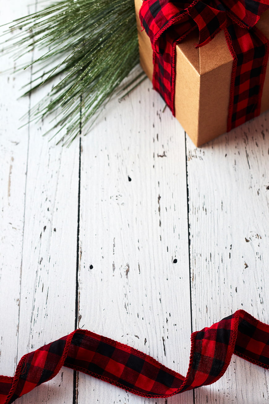 Rustic Christmas Gift Box with Plaid Ribbon on White Wood