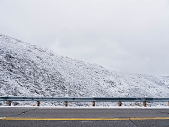 Winter Highway Roadside with Snowy Mountain Background
